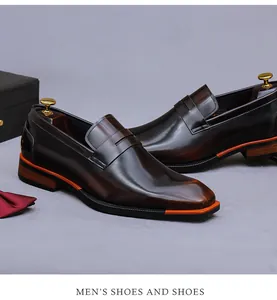 Nahaufnahme dunkelbrauner Penny Loafer aus Leder mit modernen orangefarbenen Akzenten
