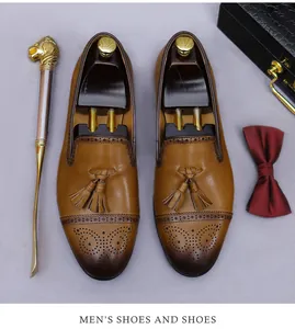 Detalle de zapatos brogue de cuero marrón con borlas y perforaciones decorativas de gala