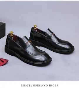 Vista macro de mocasines de charol negro con detalles naranja y perforaciones brogue