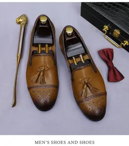 Detalle de zapatos brogue de cuero marrón con borlas y accesorios de cuidado de lujo
