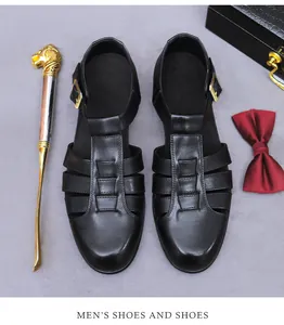 Detail von schwarzen Leder-Sandalen mit geschlossenem Zehenbereich und goldener Schnalle