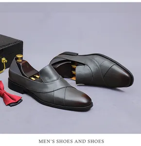 Detail of dark gray leather loafers with cross-strap design and formal gift accessories