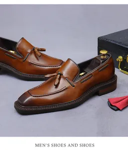 Detailopname van donkerbruine loafers met kwastjes en handgemaakte kleurverloopafwerking
