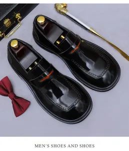 Detalle de zapatos brogue en cuero negro brillante con elegantes perforaciones decorativas