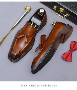 Close-up van bruine leren kwastjes loafers met handbeschilderde afwerking en vlechtwerk