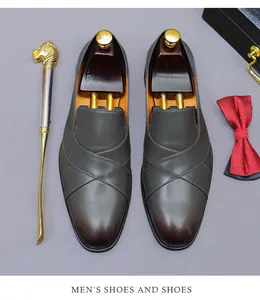 Top view of premium gradient leather loafers with wooden shoe tree and metal shoe horn