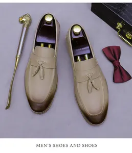 Flat lay of men's leather tassel loafers with gradient toe and business accessories