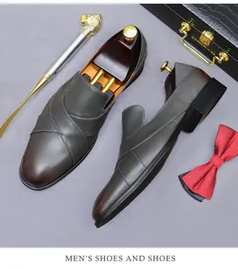 Detail of leather loafers with cross-layer design beside briefcase and cane accessories