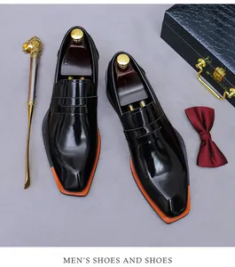 Detailansicht von schwarzen Lacklederschuhen mit oranger Sohle und Luxus-Accessoires