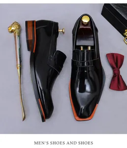 Makro-Detail von schwarzen Lackleder-Loafers mit orangefarbener Sohle und Holzmaserung-Absatz