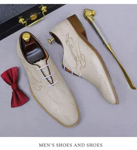 Top view of beige leather oxfords featuring decorative script engraving and dress accessories
