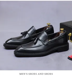 Detail van zwarte lederen loafers met kwastjes, geweven zijkanten en zakelijk design