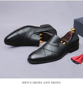 Detail view of men's black leather loafer with cross-over strap design and business props