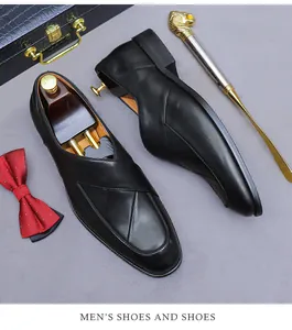 Formal black leather shoes with detailed stitching, shoe horn, and business accessories