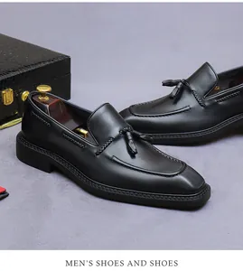 Macro detail van zwarte leren loafers met klassieke kwast en hoogwaardige U-stiksels