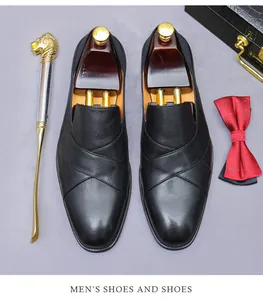 Close-up of black leather loafers with cross-strap design and luxury shoe care accessories