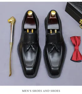 Platte weergave van zwarte leren tassel loafers met schoenspanners en chique accessoires