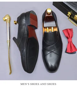 Formal black leather loafers with luxury accessories including a golden lion shoehorn