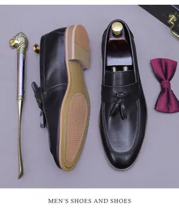 Detail of black pebbled leather tassel loafers with non-slip rubber sole and wood grain heel