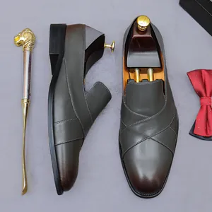 Men's dark grey leather loafers with gradient toe, metal shoe horn and bowtie accessory