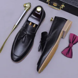 Classic men's black leather tassel loafers with a vintage business casual aesthetic