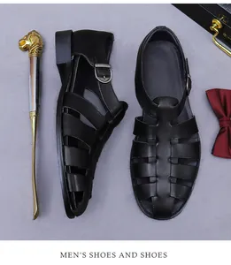 Detail of black leather men's sandals with silver buckle on a textured gray background
