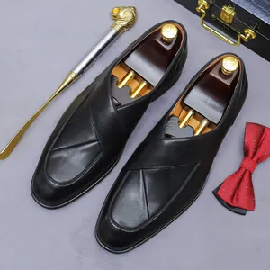 Classic black leather loafers with cross-fold detail and elegant business accessories