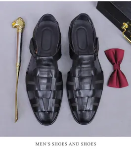 Flachbild von schwarzen geflochtenen Ledersandalen für Herren mit goldenem Schuhanzieher