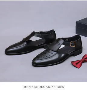 Close-up of black hollow-out leather sandals with golden metal buckle and engraved details