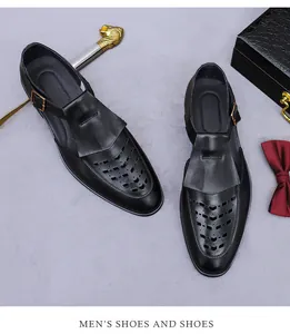 Detail of black leather monk strap shoe with intricate perforated patterns and metal buckle