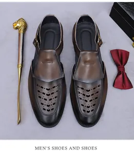 Flat lay of brown leather hollow-out men's sandals with metal buckle and luxury props