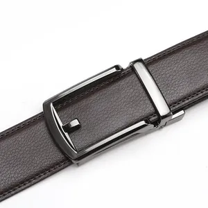 Detail of dark brown lychee grain leather belt with a minimalist grey metal automatic buckle