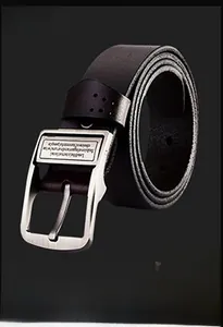 Detailed macro view of men's leather belt with brushed metal pin buckle and engraved logo