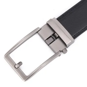 Detail of gunmetal brushed buckle and black carbon fiber textured leather belt for men