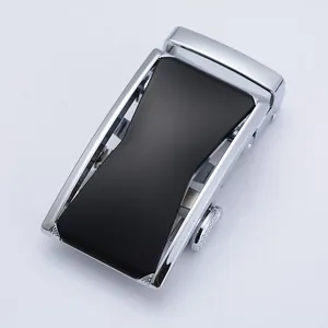 Macro shot of silver metal automatic belt buckle with a textured black matte panel center