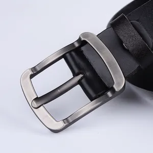 Macro shot of gunmetal brushed pin buckle and black pebble grain leather on men's belt