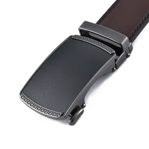 Close-up of men's brown leather belt featuring a gunmetal buckle with greek key patterns
