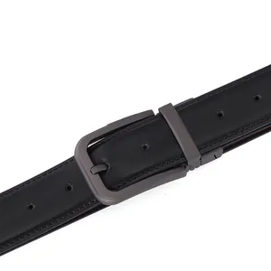 Close-up of matte grey metal buckle and black leather belt with fine reinforced stitching