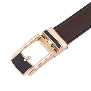 Close-up of rose gold automatic buckle with carbon fiber texture and brown leather belt