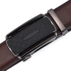 Detail of men's brown leather belt with lychee texture and textured metal buckle