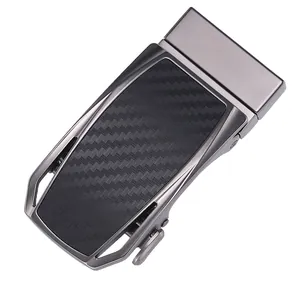Detail of gunmetal alloy automatic belt buckle with black carbon fiber inlay texture