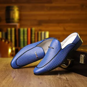 Detail of blue perforated leather mule loafers with metal buckle on vintage wooden background