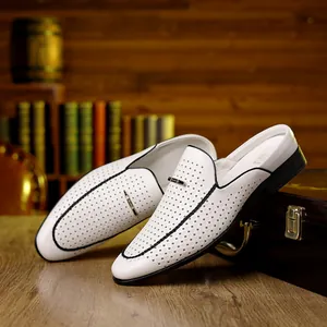 Detail of white laser-cut leather mule featuring black contrast stitching and metal trim