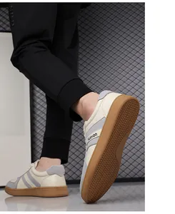 Detailaanzicht van de bruine rubberen antislipzool op deze witte leren herensneakers