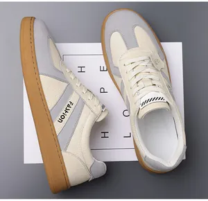 Detail van hoogwaardig beige leer en grijs suède patchwork op retro casual sneakers
