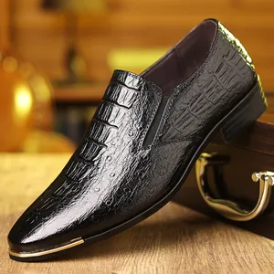 Detalle de mocasín negro con textura de cocodrilo y elegante puntera de metal dorado