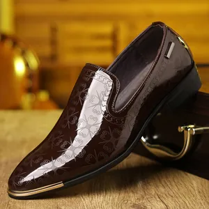 Brown patent leather loafers with floral pattern and gold trim on wooden stand
