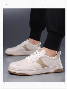 Detalle de zapatillas de hombre en blanco crema con texto fashion y toques marrones