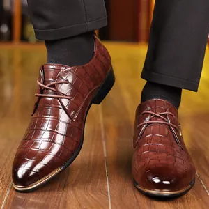 Detail of dark reddish-brown leather oxford shoes with crocodile texture and gold toe cap