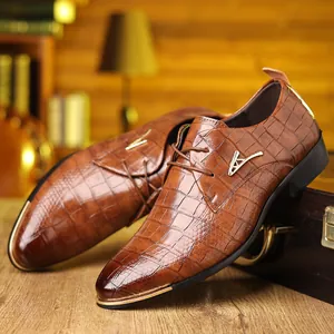 Detail of brown crocodile embossed leather derby shoe with gold metallic toe cap